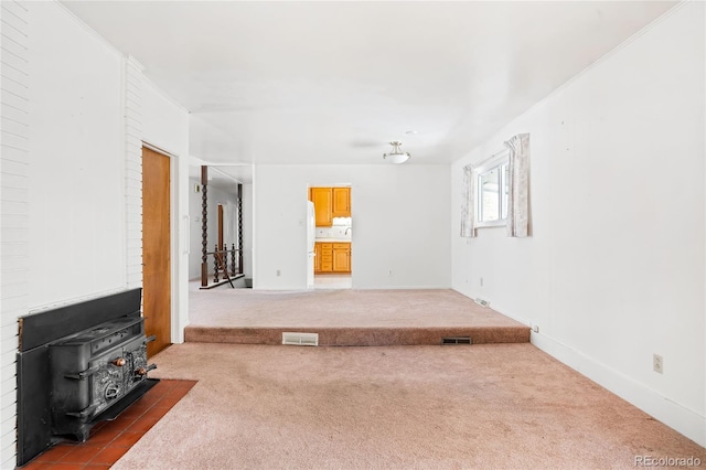 carpeted living room with a wood stove