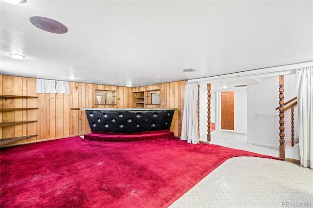 basement with carpet flooring and wood walls