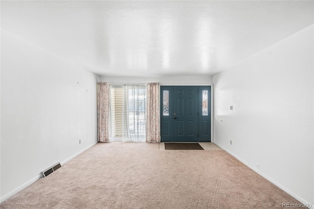 view of carpeted foyer entrance