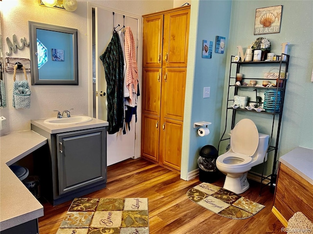 bathroom featuring vanity, hardwood / wood-style floors, and toilet