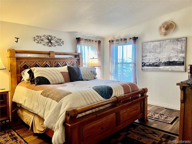 bedroom with vaulted ceiling and dark hardwood / wood-style floors