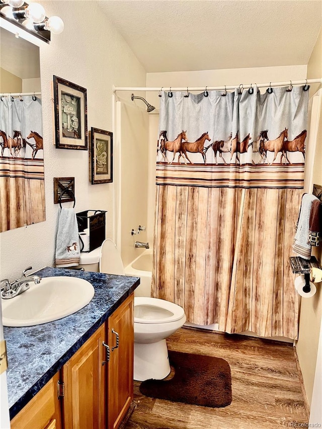 full bathroom featuring toilet, a textured ceiling, vanity, shower / bath combo with shower curtain, and hardwood / wood-style flooring