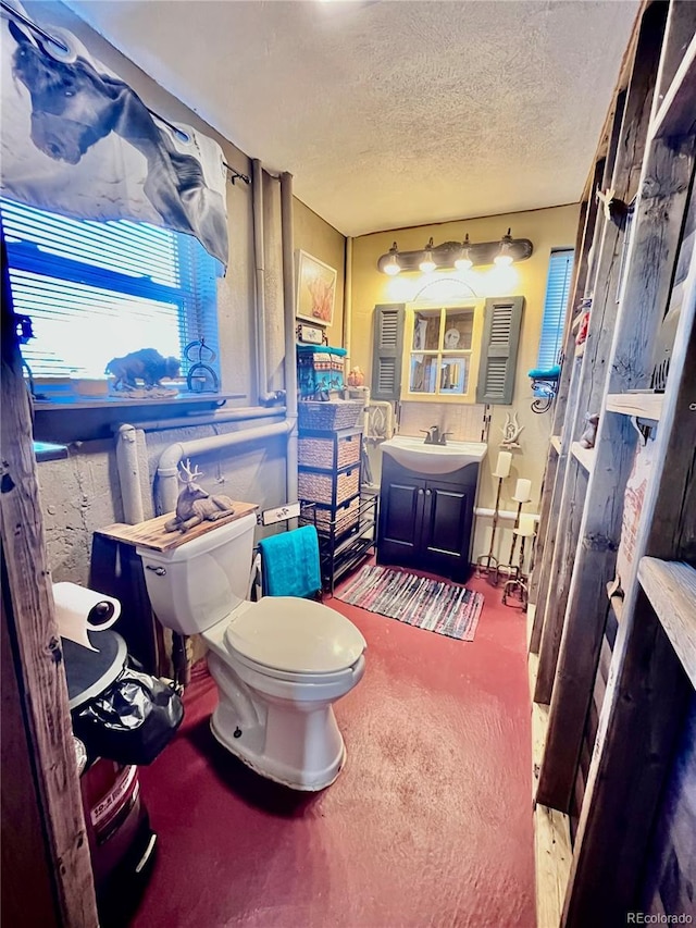 bathroom featuring vanity, toilet, and a textured ceiling