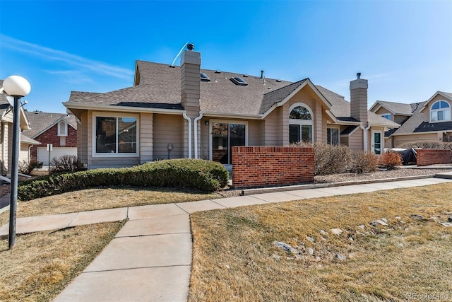 view of front of property with roof with shingles and a chimney