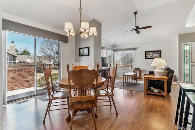 dining area featuring wood finished floors, ceiling fan with notable chandelier, and visible vents