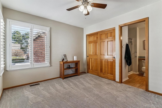 unfurnished bedroom with visible vents, baseboards, carpet, ensuite bathroom, and a closet