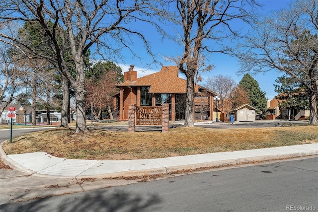 view of front facade with brick siding and a chimney