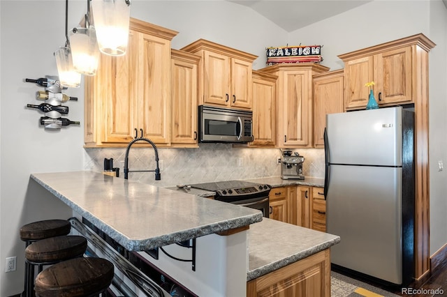504 Ravenwood Dr Unit B2, Grand Lake, CO 80447 - kitchen featuring stainless steel appliances, a peninsula, light brown cabinetry, a breakfast bar area, and backsplash