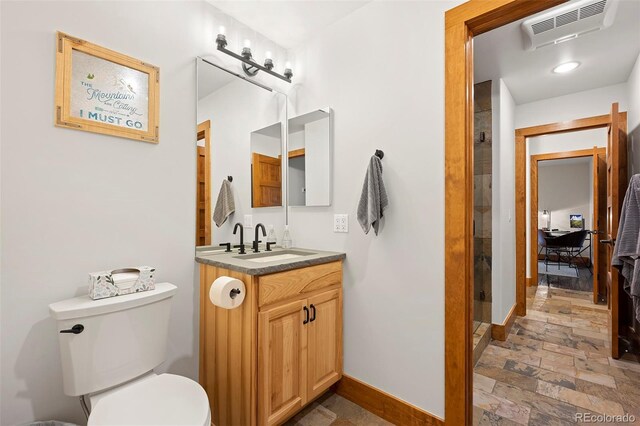 504 Ravenwood Dr Unit B2, Grand Lake, CO 80447 - bathroom featuring baseboards, vanity, toilet, a shower stall, and stone tile floors