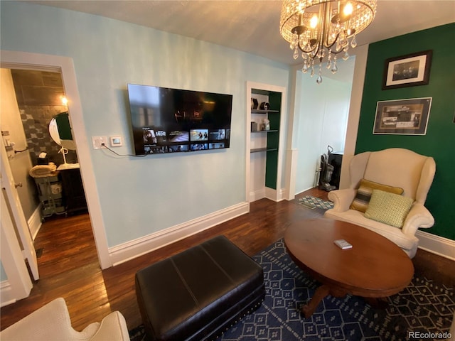 living area featuring an inviting chandelier, wood finished floors, and baseboards