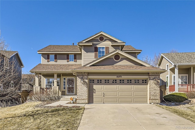 traditional-style home featuring driveway, a garage, a shingled roof, covered porch, and brick siding