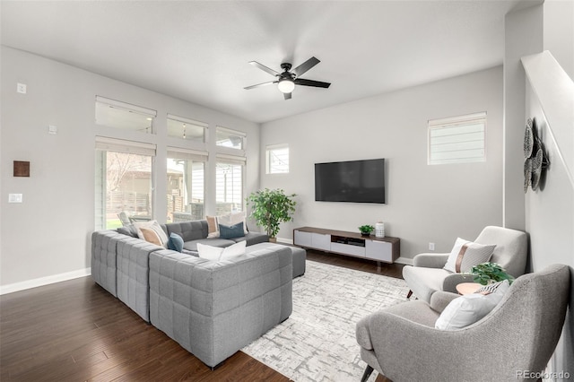 living room featuring baseboards, dark wood-style floors, and a ceiling fan