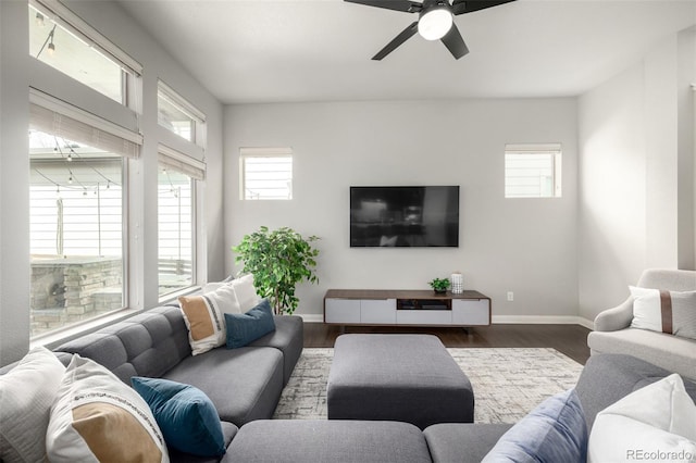 living area featuring a ceiling fan, wood finished floors, and baseboards