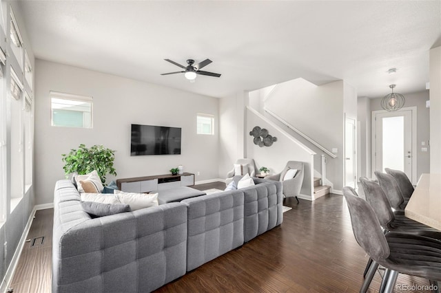living room featuring stairway, visible vents, dark wood-style flooring, and baseboards