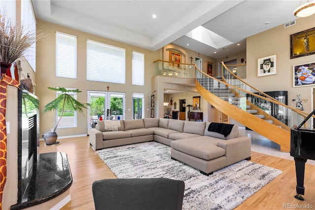 69 N Ranch Rd, Littleton, CO 80127 - living room featuring stairs, a towering ceiling, wood finished floors, a tray ceiling, and recessed lighting