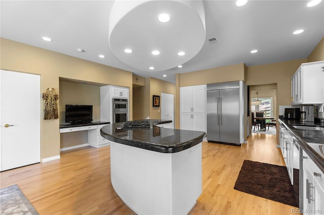69 N Ranch Rd, Littleton, CO 80127 - kitchen with stainless steel appliances, dark countertops, light wood finished floors, white cabinetry, and a sink