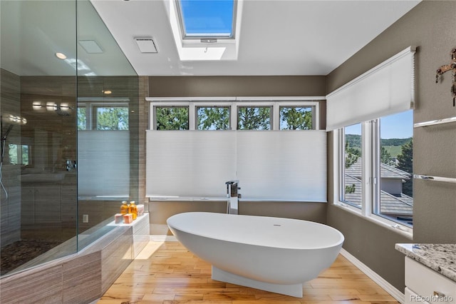 69 N Ranch Rd, Littleton, CO 80127 - full bath featuring a freestanding tub, wood finished floors, a skylight, a stall shower, and vanity