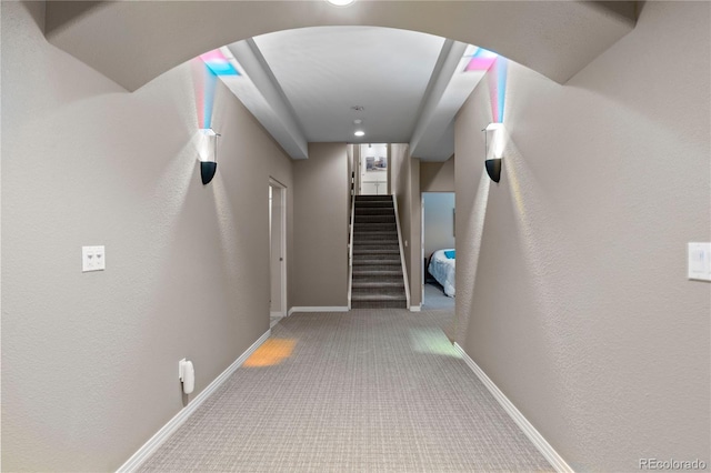 69 N Ranch Rd, Littleton, CO 80127 - hall with carpet, arched walkways, baseboards, a textured wall, and stairs