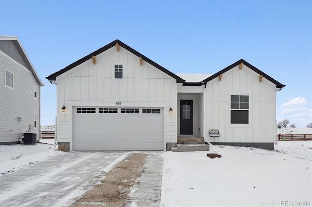 view of front of house with a garage and central air condition unit