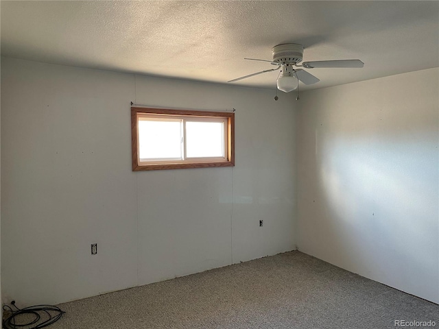 carpeted spare room with ceiling fan and a textured ceiling