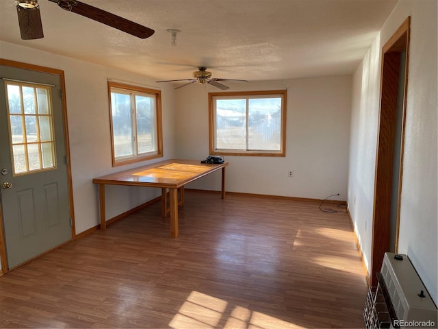 unfurnished dining area featuring wood-type flooring and ceiling fan