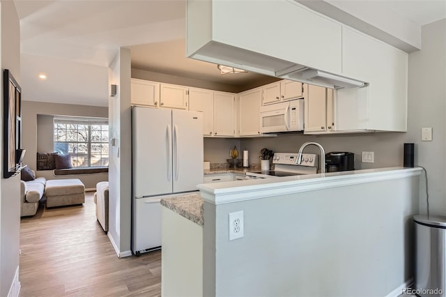 kitchen with white cabinetry, light hardwood / wood-style flooring, white appliances, and kitchen peninsula