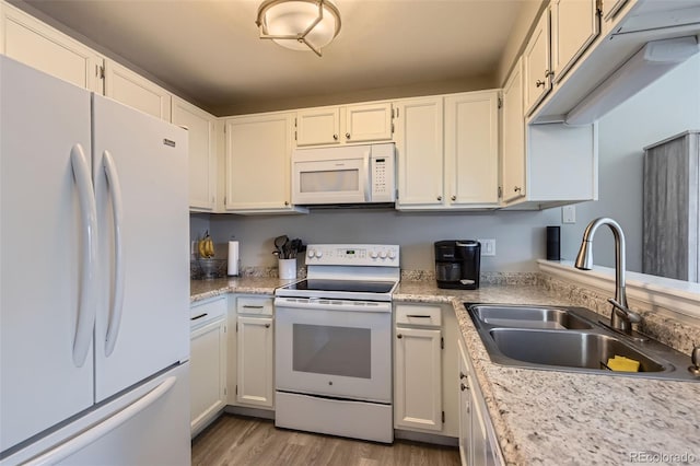 kitchen featuring white cabinetry, sink, white appliances, and light hardwood / wood-style floors