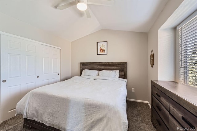 bedroom featuring dark colored carpet, vaulted ceiling, ceiling fan, and a closet