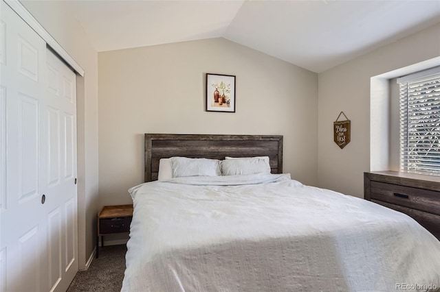 bedroom featuring lofted ceiling, a closet, and carpet flooring