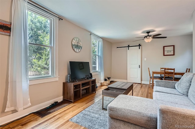 3655 Zenobia St, Denver, CO 80212 - living room with a barn door, wood finished floors, a ceiling fan, and baseboards