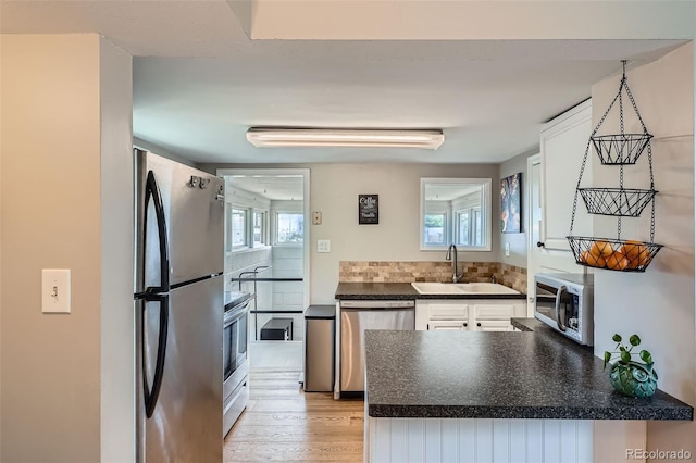 3655 Zenobia St, Denver, CO 80212 - kitchen with appliances with stainless steel finishes, a sink, dark countertops, white cabinetry, and healthy amount of natural light
