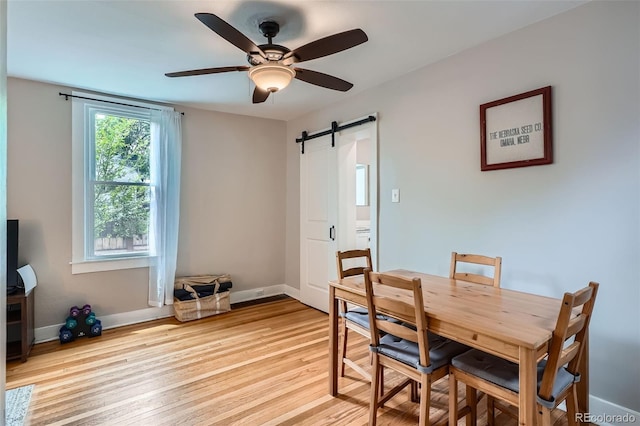 3655 Zenobia St, Denver, CO 80212 - dining space with a barn door, light wood-style flooring, a ceiling fan, and baseboards