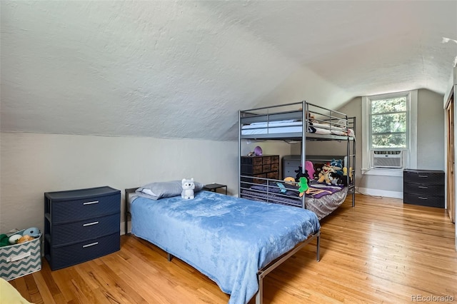 3655 Zenobia St, Denver, CO 80212 - bedroom featuring wood finished floors, vaulted ceiling, a textured ceiling, cooling unit, and baseboards