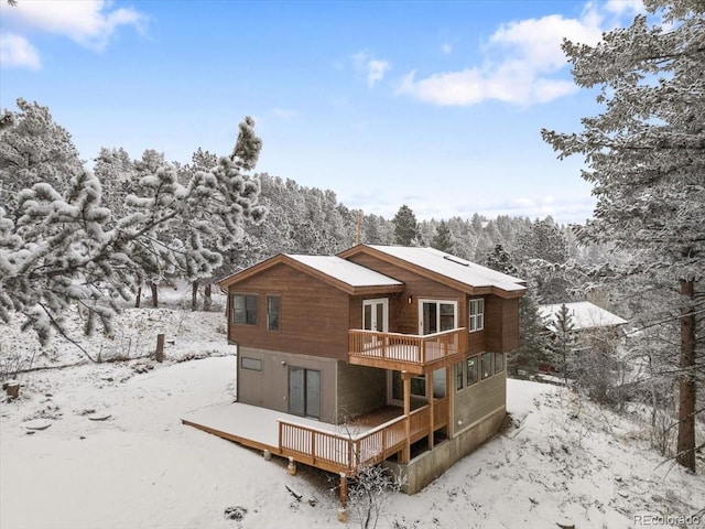 snow covered property with a wooden deck