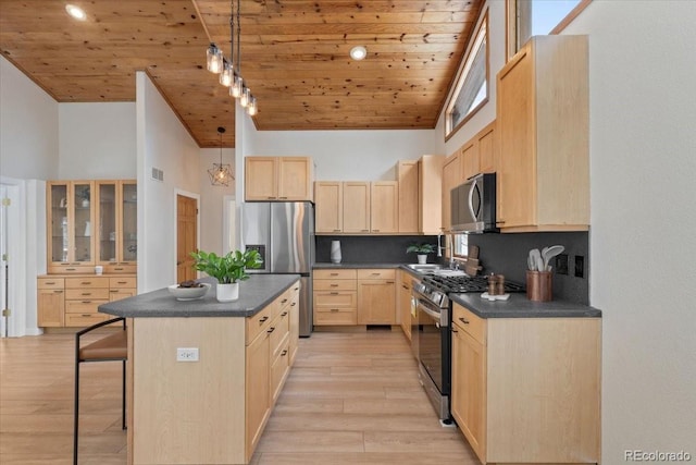 kitchen featuring stainless steel appliances, dark countertops, and light brown cabinets