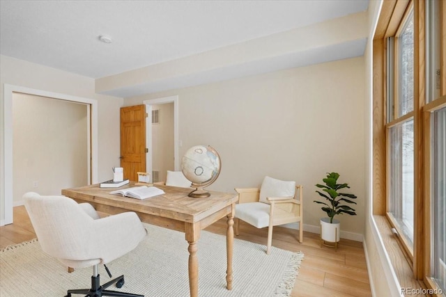 home office with light wood-style floors, baseboards, and visible vents