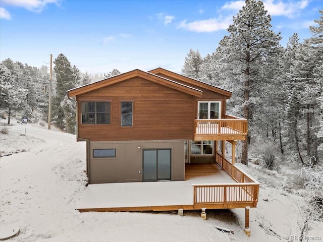 snow covered house with a wooden deck