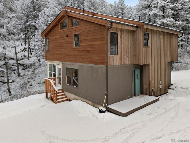 view of snow covered rear of property