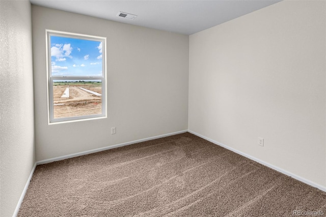 carpeted spare room with visible vents and baseboards