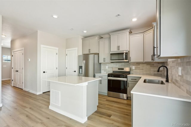 17943 E 94th Pl, Commerce City, CO 80022 - kitchen featuring appliances with stainless steel finishes, backsplash, light countertops, light wood-style flooring, and a kitchen island
