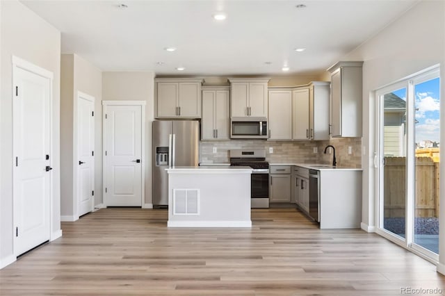 17943 E 94th Pl, Commerce City, CO 80022 - kitchen with stainless steel appliances, gray cabinetry, light countertops, light wood-style flooring, and backsplash