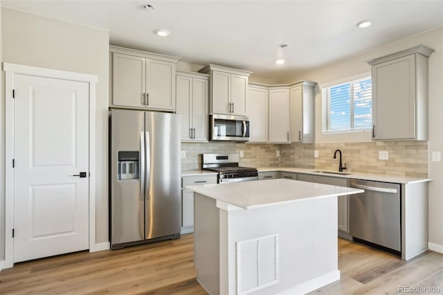 17943 E 94th Pl, Commerce City, CO 80022 - kitchen featuring stainless steel appliances, light countertops, decorative backsplash, light wood finished floors, and a center island
