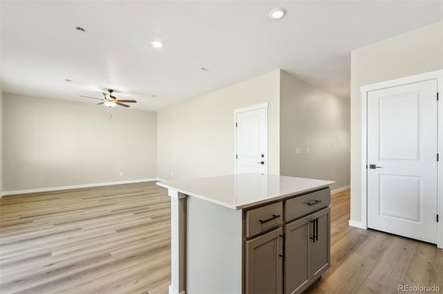 17943 E 94th Pl, Commerce City, CO 80022 - kitchen featuring gray cabinets, ceiling fan, light wood-style floors, a kitchen island, and light countertops