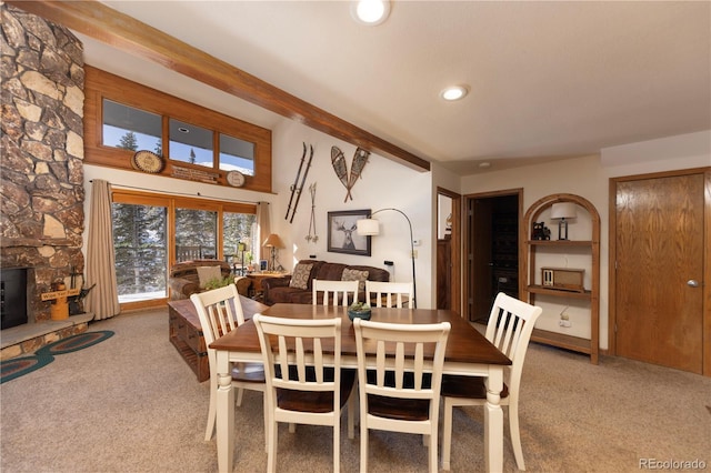 carpeted dining room featuring a stone fireplace, beam ceiling, and recessed lighting