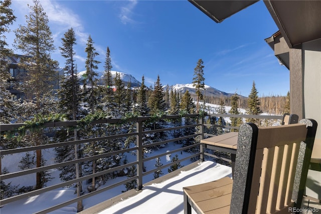 snow covered back of property with a mountain view