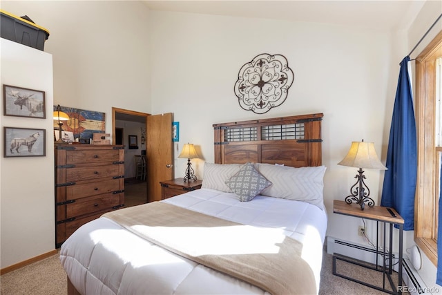 carpeted bedroom with a high ceiling, baseboards, and a baseboard radiator