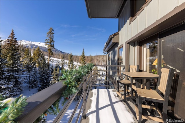 snow covered back of property with a mountain view