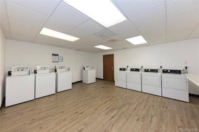 community laundry room with light wood-style floors and washer and clothes dryer