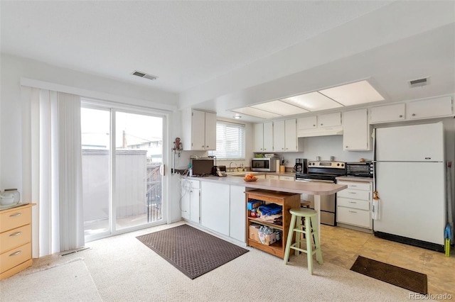 kitchen featuring stainless steel appliances, light countertops, visible vents, and white cabinets