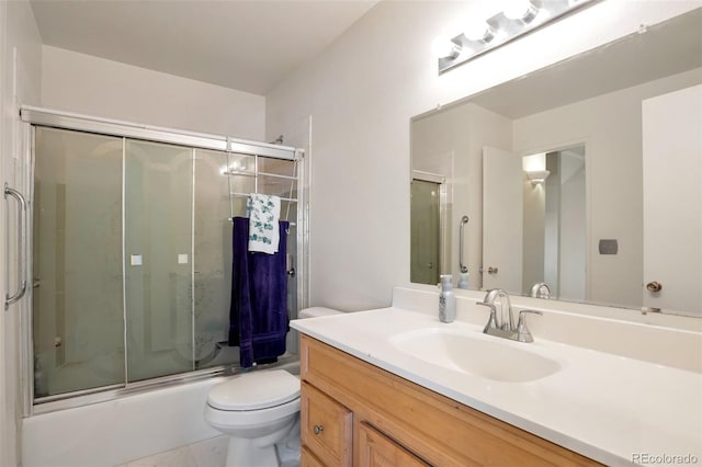 bathroom featuring toilet, vanity, tile patterned floors, and bath / shower combo with glass door